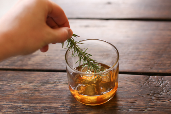 stirring your drink with a rosemary sprig