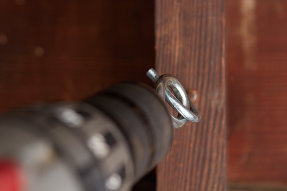 drill using a hook eye to turn a screw hook