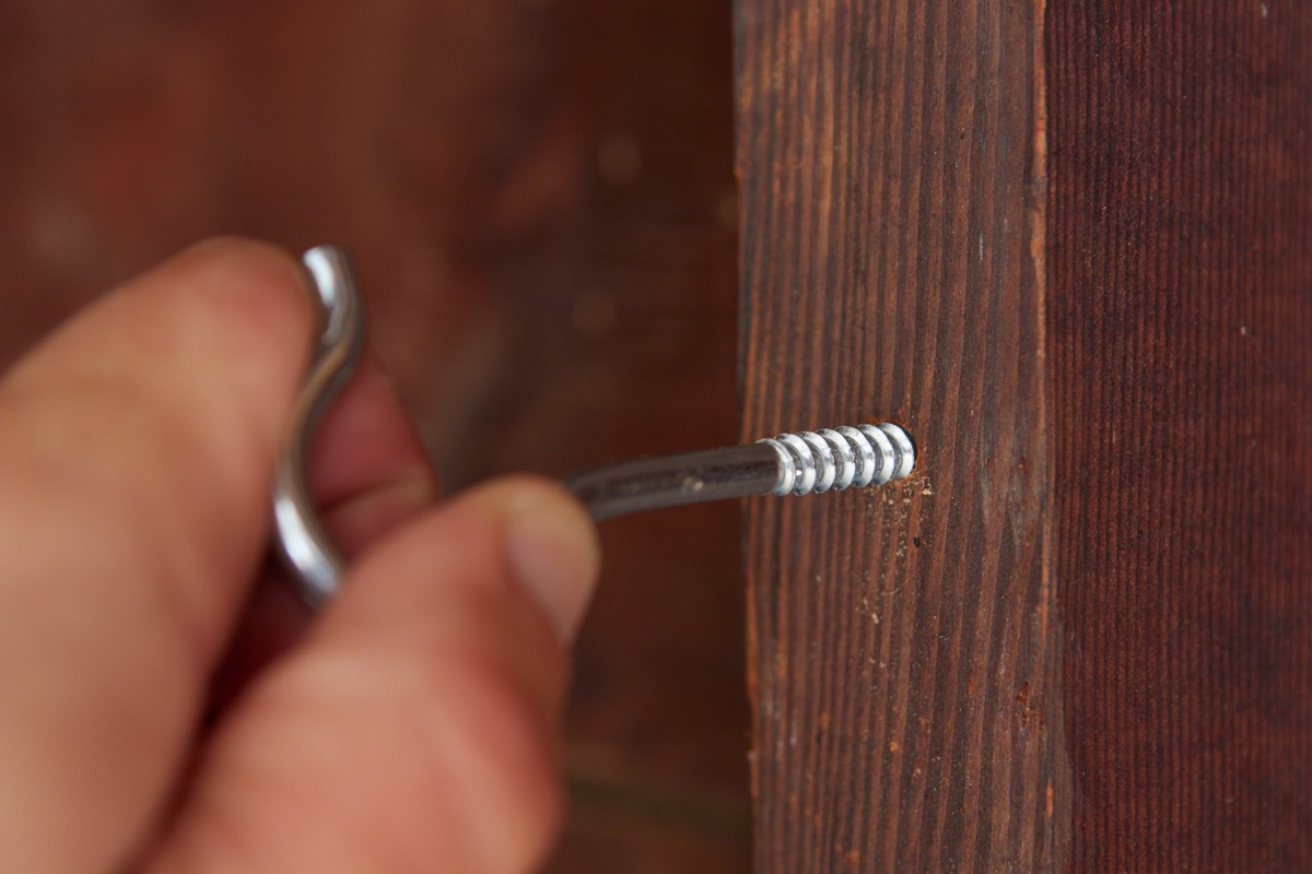screw hook being inserted into pilot hole