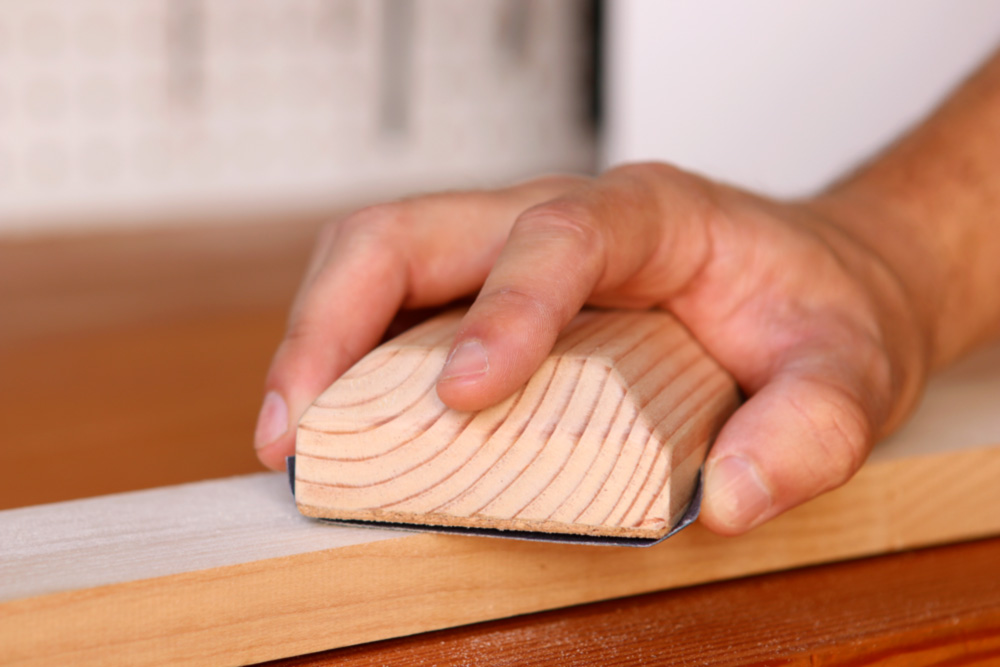 using a sanding block to sand wood