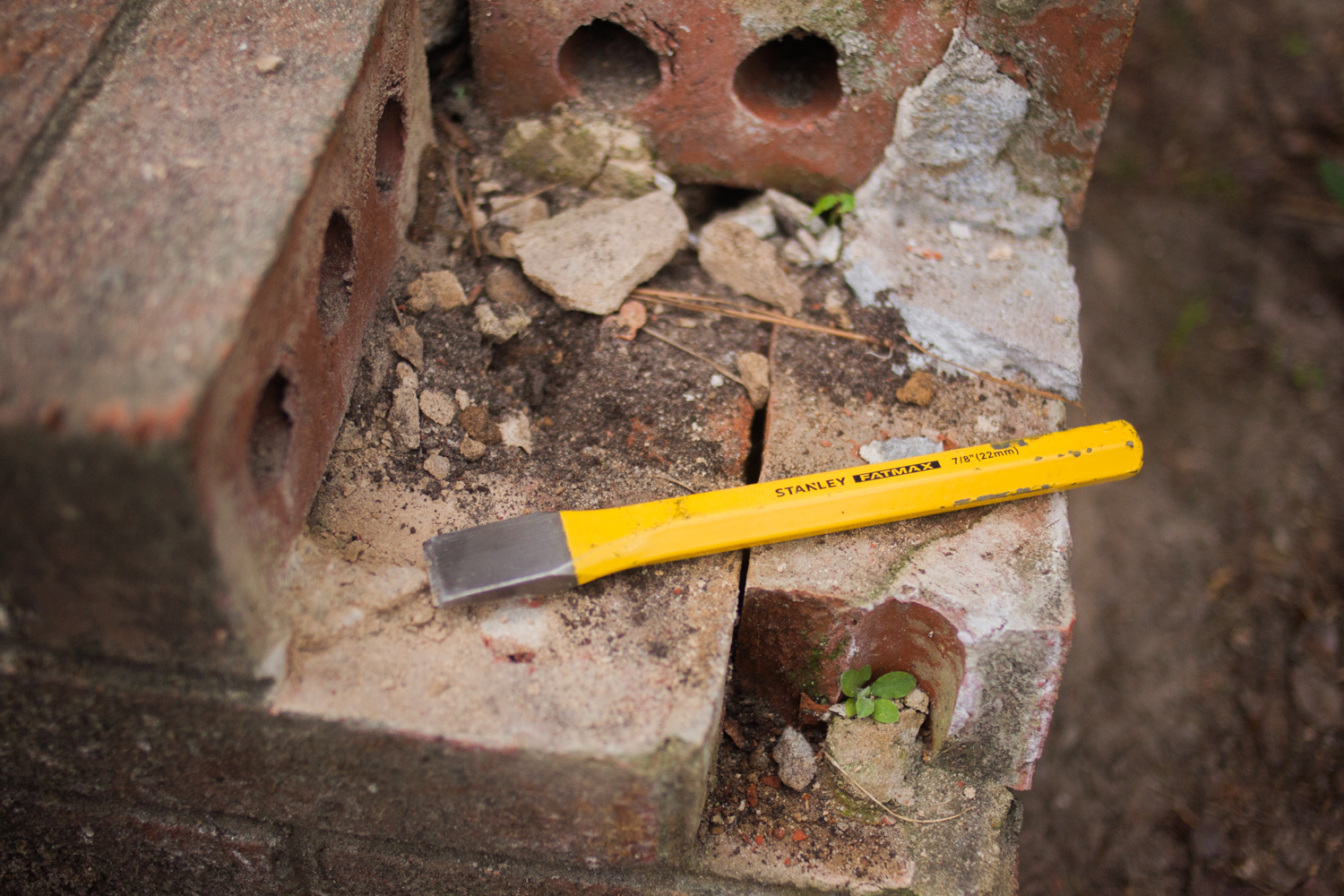 chisel clearing away damaged mortar and bricks