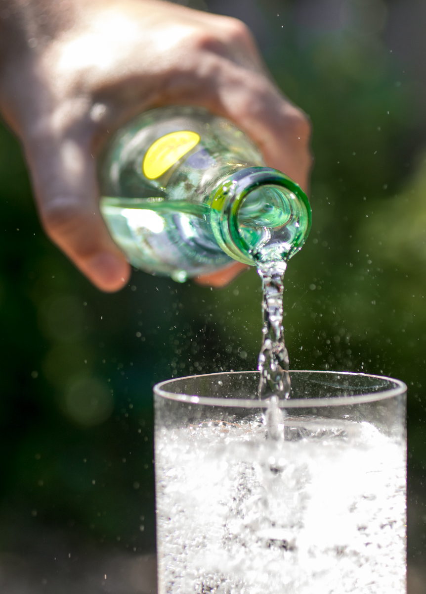 Topo Chico sparkling water bottle poured over ice