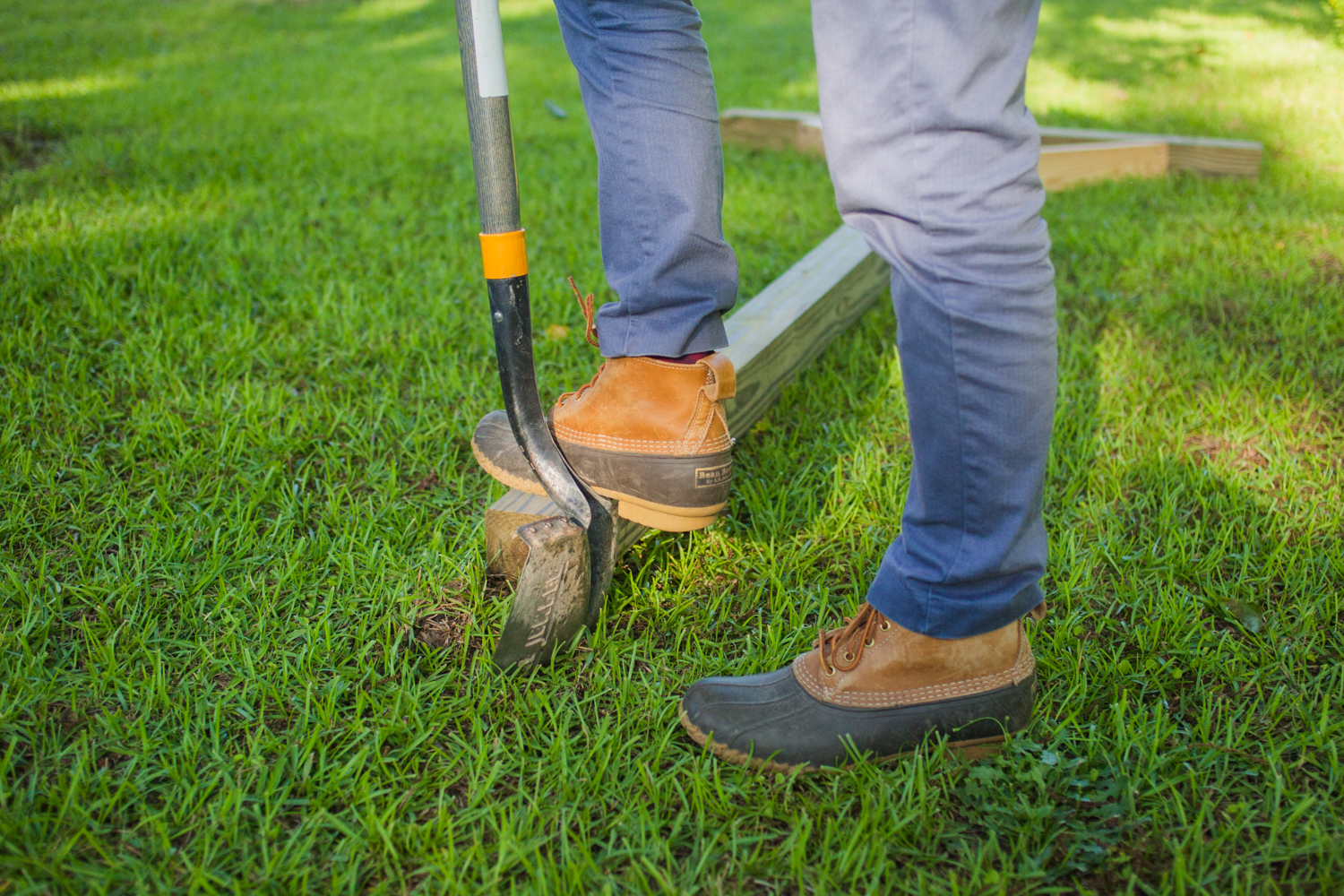 man digging holes for clothesline post