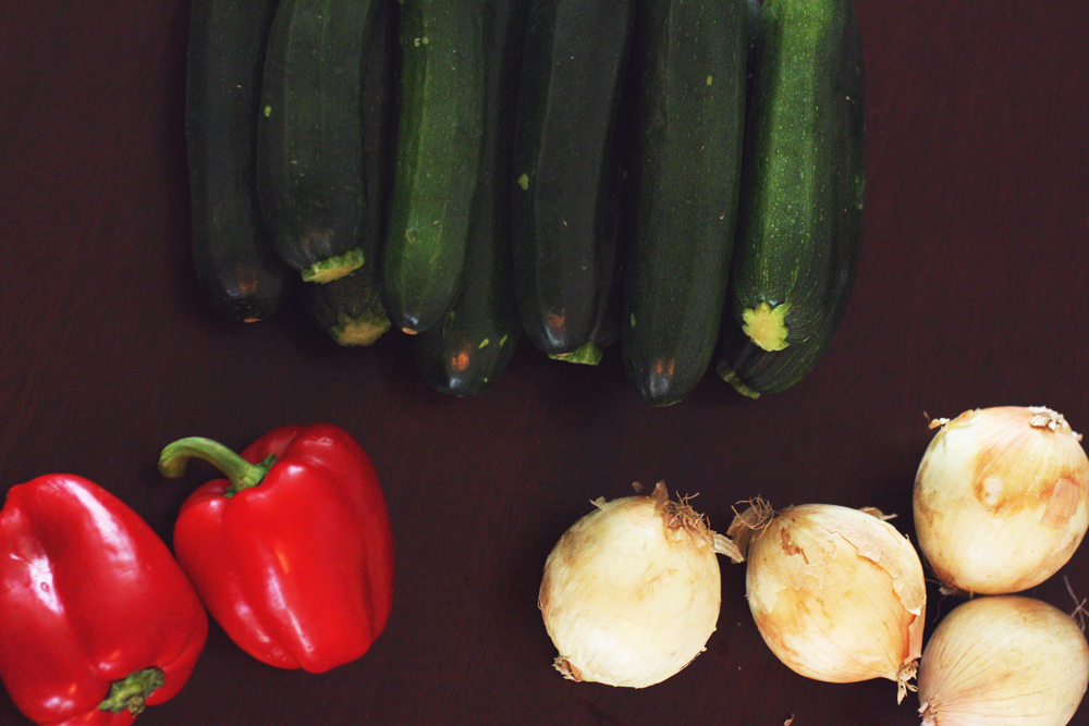 Red bell peppers, yellow onion, and zucchnini