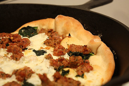 pizza cooked in a heated cast iron skillet